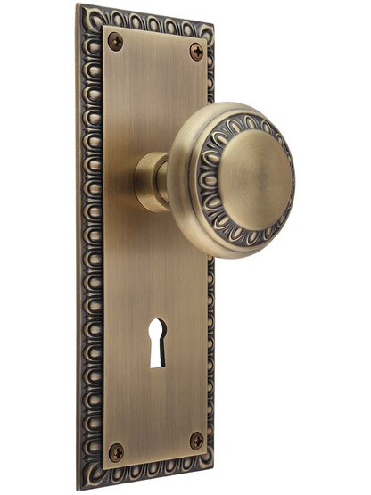 Ovolo Mortise-Lock Set with Matching Knobs in Antique Brass.